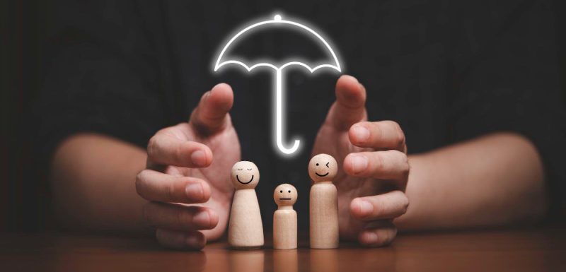 businessman-two-hands-protecting-family-wooden-model-for-insurance-and-assurance-life-concept